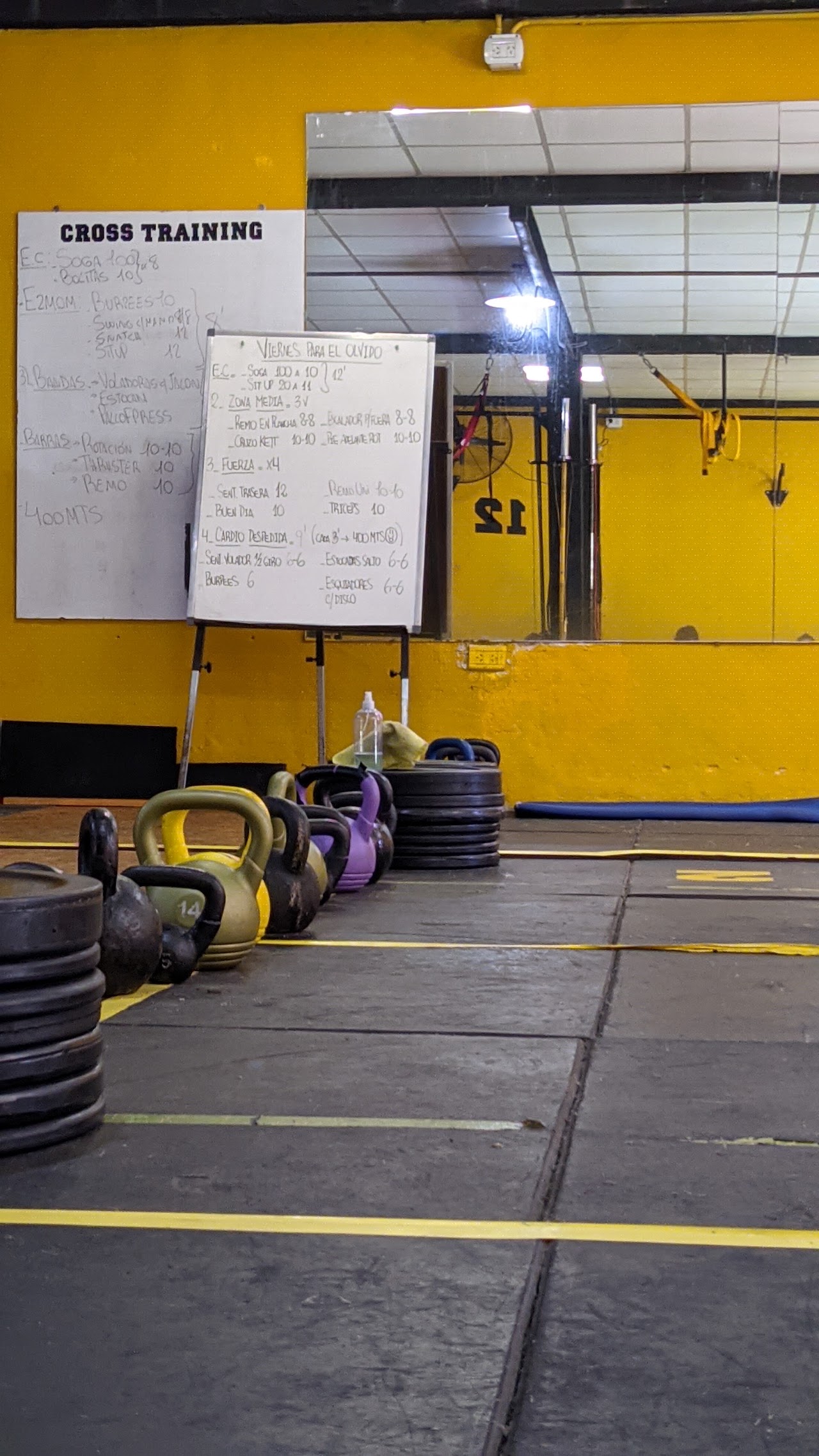 Pizarra con la rutina del día y set de kettlebells