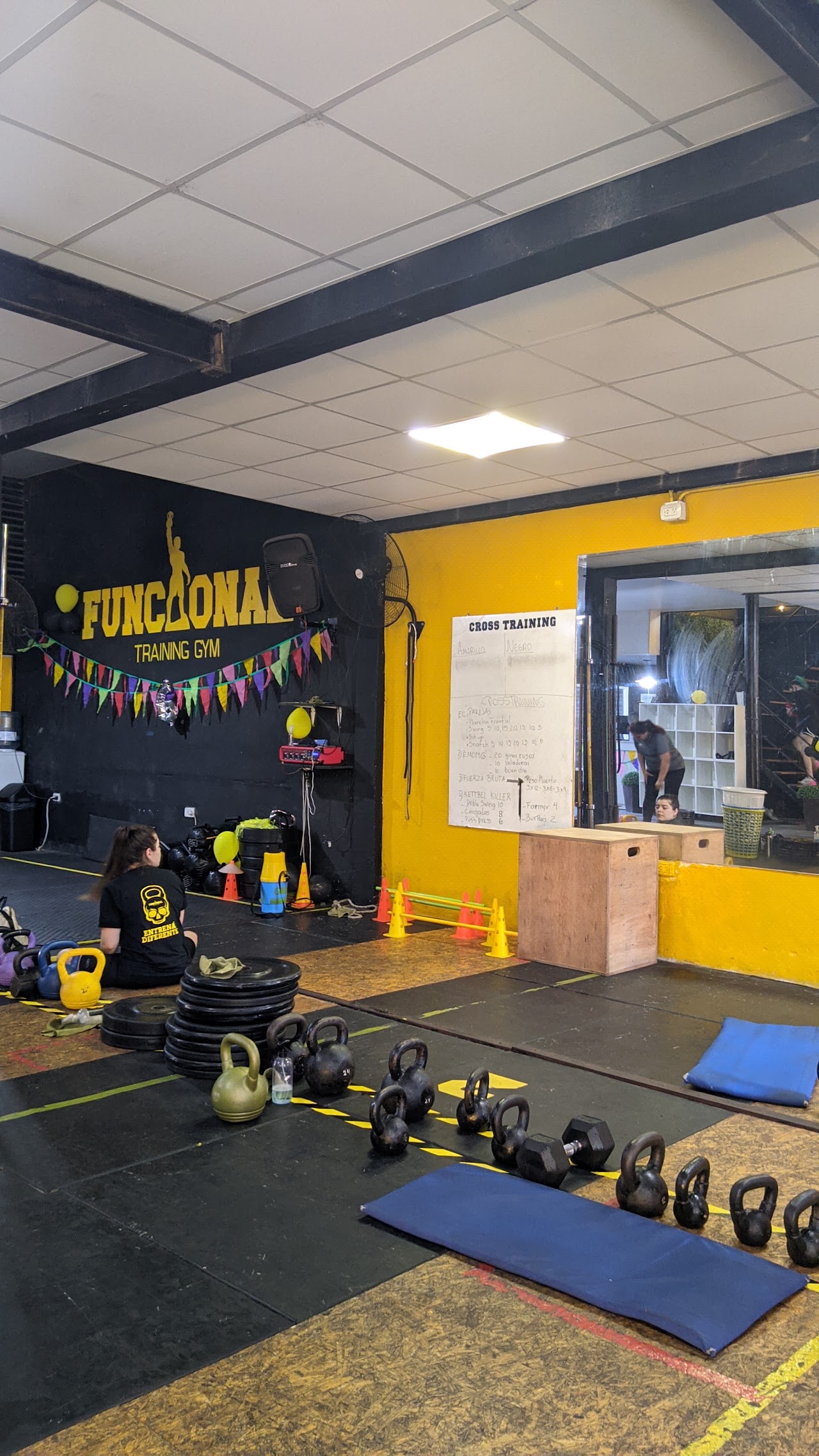 Pared con cartel de FUNCIONAL TRAINING GYM y equipamiento de cross training